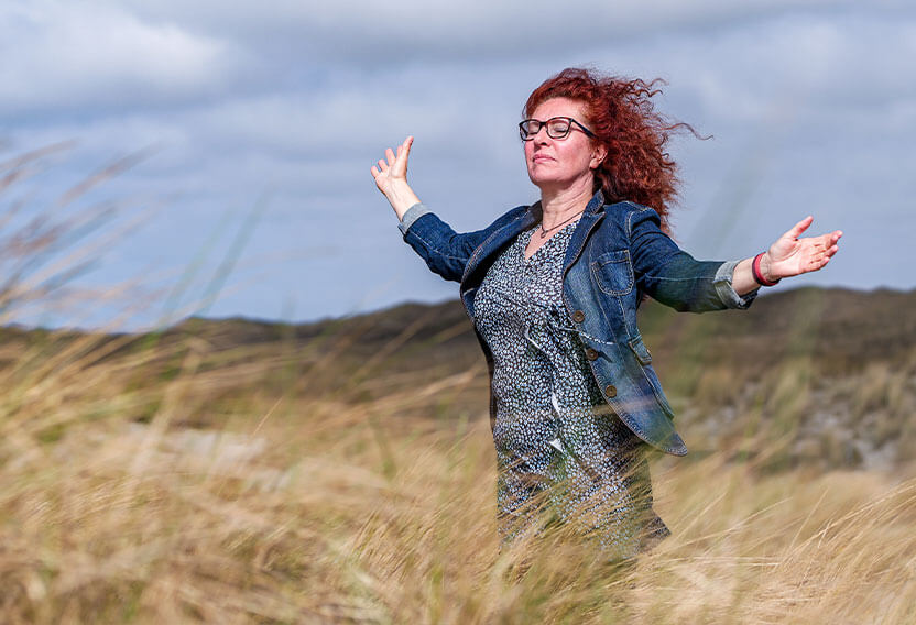 Silke in einer Dünenlandschaft – Blick in den Himmel, aber die Augen geschlossen